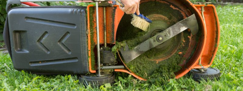 man cleaning lawn mower